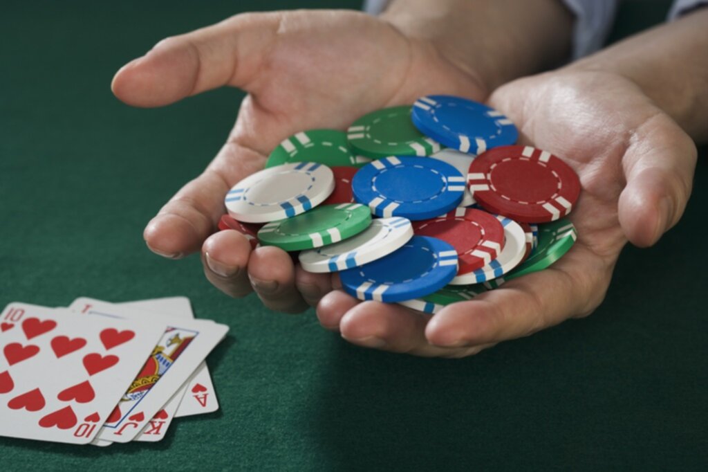 Poker player holding the poker chips he just won on a hand