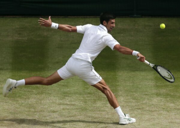 Novak Djokovic playing tennis at wimbledon grass court